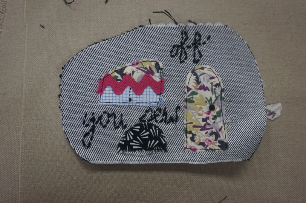 Ater adding the curtain to the window, place and embroider all pieces on to the side panels. I added a french knot to the door for a handle, and the window for a drawstring. I also embroidered "Off you sew" to the caravan's side. HINT: Use the pattern to help with placement of pieces.