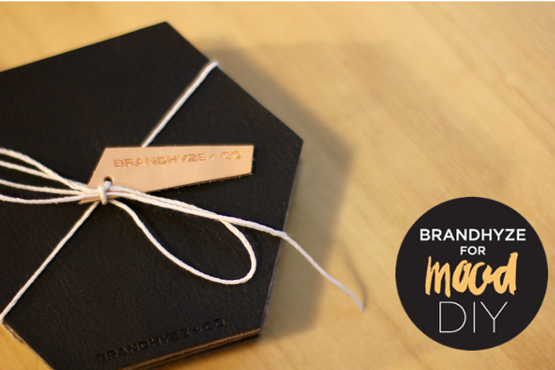 A stack of the leather and felt coasters with the leather side facing, tied together with string. An icon displaying 'Brandhyze for Mood DIY.'