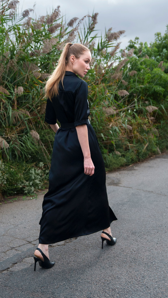 Model walking outdoors in long Black Double-Face Silk Charmeuse 36mm Axel Shirt Dress Free Sewing Pattern by Mood Fabrics Sewicety Blog with waist tie belt and short sleeves, styled with black high heels.