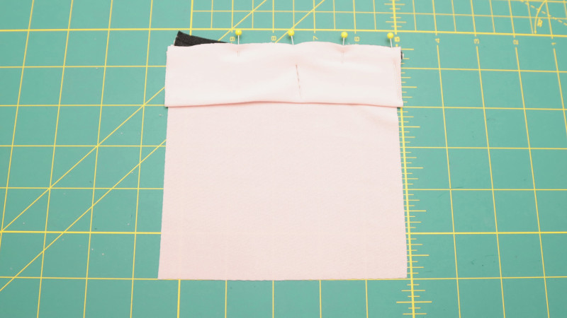 Create the front pocket by joining the pocket top to the pocket pattern, sewing them together with piping in between. Top stitch across the bottom of the piping to make the pocket lay flat.
