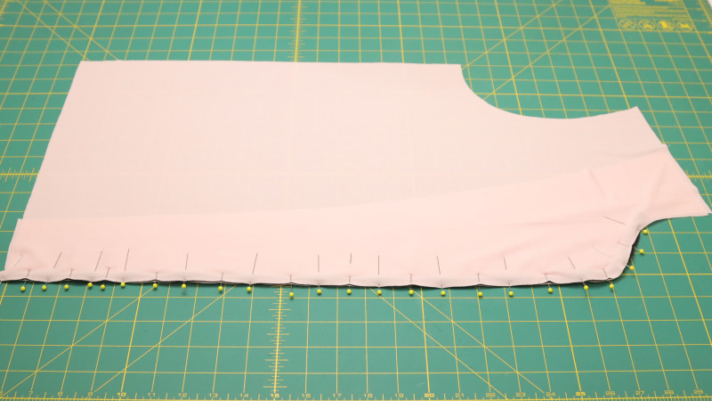 Sew the front facing along the front opening with piping in between. Sew up to the collar end notch. Repeat this step for both sides of the front.