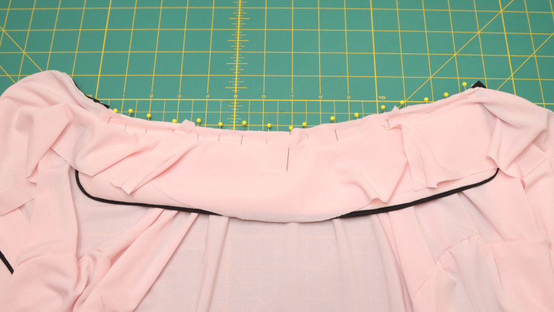 Pin the collar around the neckline of the shirt, then pin the Top Back Facing over the collar. Sew the Collar sandwiched between the neckline and the back facing. Pin the back facing to the back and top stitch around the edge to keep it in place.