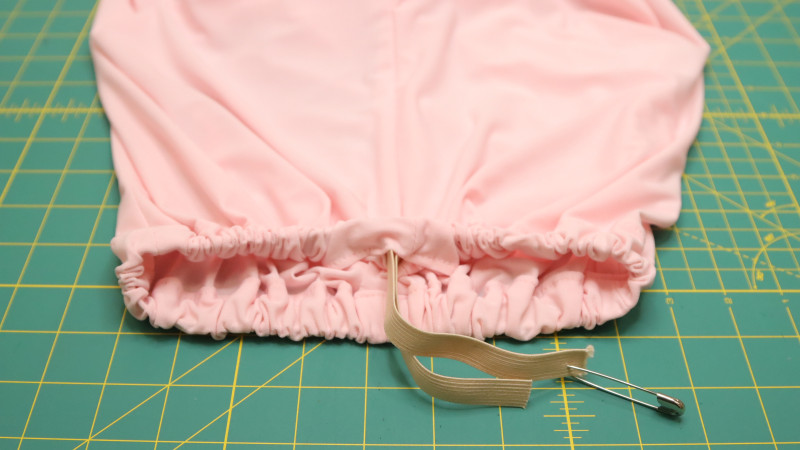 Use a safety pin to insert the elastic through the opening, around the entire waistline, and back out of center back.