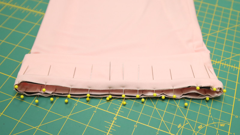 Sew the cuffs to the bottom of the pants with piping in between.
