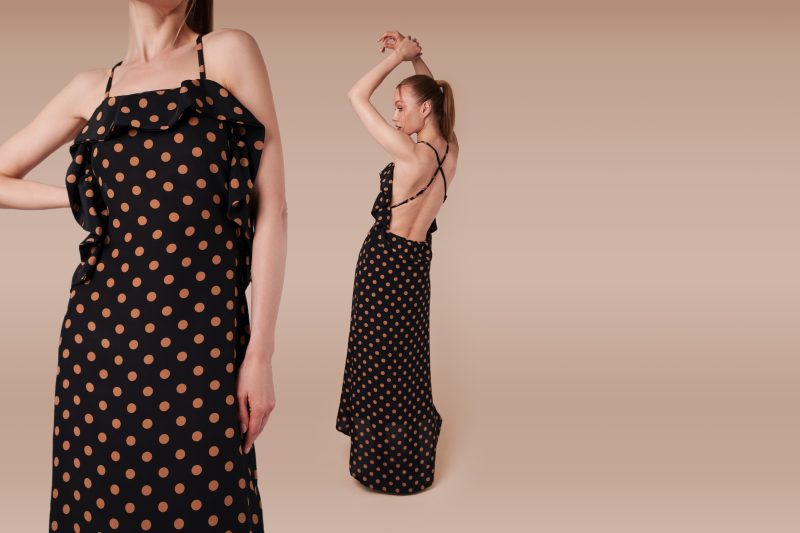 Close up view of front and back view of polka dot sweep dress with model holding her arms up