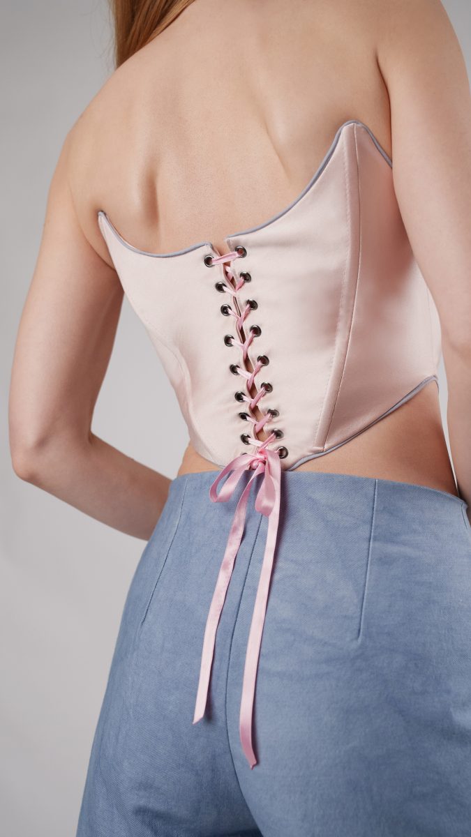 Back view of pink brocade and satin corset with ribbon tie closure.