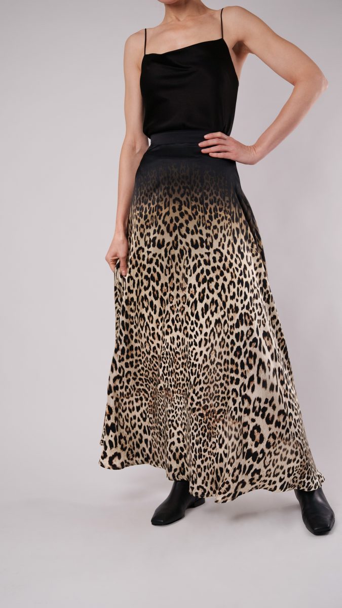 Full-length view of Fiera Maxi Skirt free sewing pattern from Mood Fabrics, styled with a black satin top and ankle boots. | Fiera Maxi Skirt Free Sewing Pattern - Leopard Printed Silk Charmeuse Fashion Fabric - Model Photo Detail View - MDF416 - Mood Fabrics Sewciety Blog