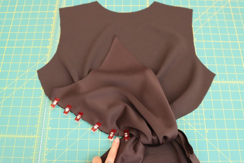 How-To-Fold-Long-Tail-Onto-Check-Section-Dark Chocolate Stretch Polyester Crepe Knit--Mood-Fabrics Fold the long tail back onto the chest section and pin the raw edges together, lining up the notches.