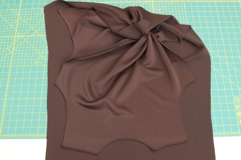 How-To-Fold-Front-Upper-Twist-Onto-Front-Lower-Twist-Dark Chocolate Stretch Polyester Crepe Knit--Mood-Fabrics Fold the front upper twist on top of the front lower twist and line up the remaining raw edges.