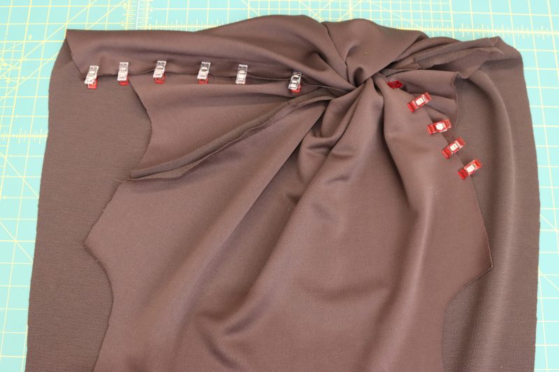 How-To-Pin-Sew-Raw-Edges-of-Each-Twist-Piece-Dark Chocolate Stretch Polyester Crepe Knit--Mood-Fabrics Pin and sew the remaining raw edges with a one inch opening at the end to leave room for the twist.