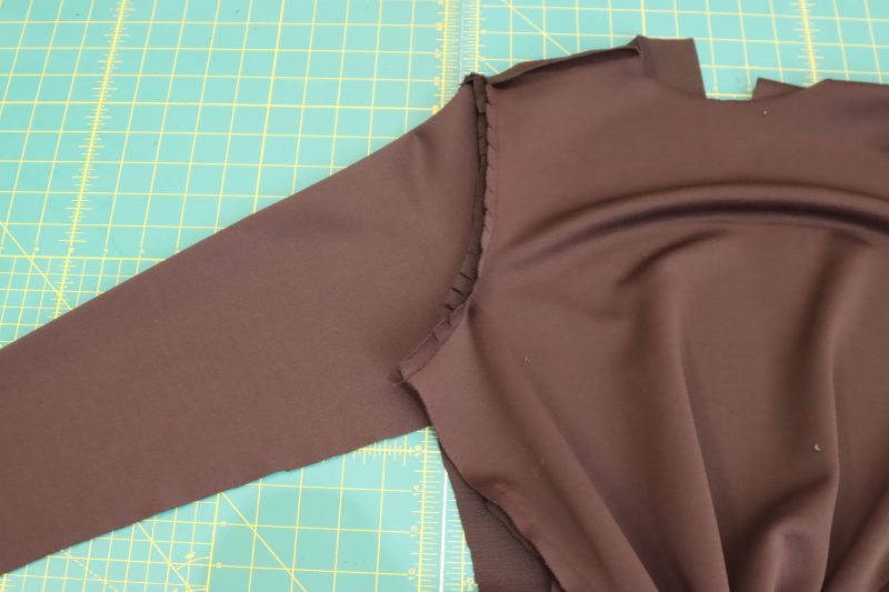 How-To-Clip-Seam-Allowance-Along-Armscye-Dark Chocolate Stretch Polyester Crepe Knit--Mood-Fabrics Clip the seam allowance along the armscye.