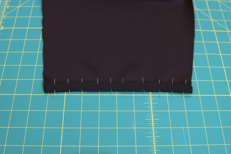 How-To-Fold-Sleeve-Hem-Dark Chocolate Stretch Polyester Crepe Knit--Mood-Fabrics Fold sleeves in by ½ inch twice, pin, and sew.