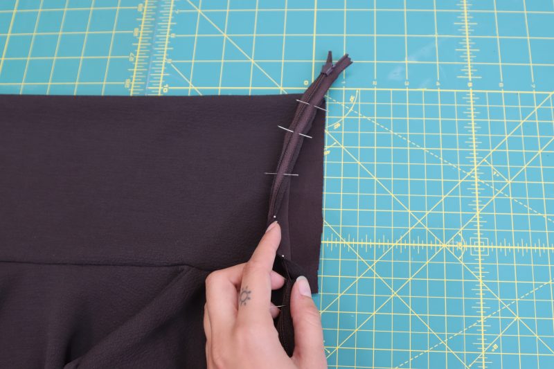 How To Ensure Zipper-Is-Pinned-To-One-Layer-Of-Collar - Invisible Zipper 24" by YKK - 917 Dark Chocolate - Nob Hill Draped Midi Dress - MDF458 - Mood Fabrics Sewciety Blog Ensure the zipper is only pinned to one layer of the top folded section of the collar.