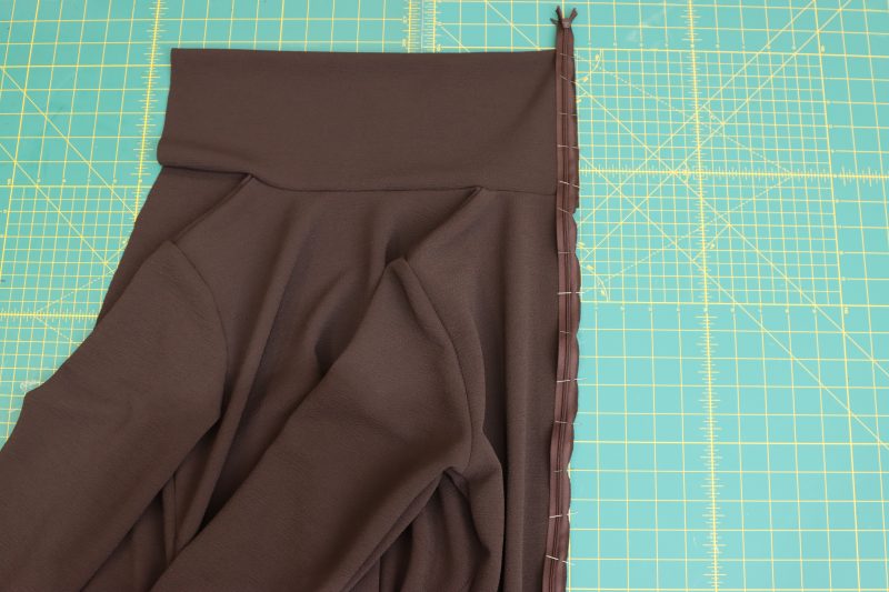 How To Pin Zipper-Right-Sides-Together-Along-Center-Back-Seam - Invisible Zipper 24" by YKK - 917 Dark Chocolate - Nob Hill Draped Midi Dress - MDF458 - Mood Fabrics Sewciety Blog Pin the zipper right sides together along the raw edge of the center back seam.