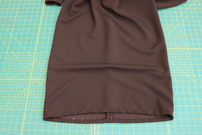 How To Pin-Sew Double-Rolled-Hem-Onto-Bottom-Hem - Dark Chocolate Stretch Polyester Crepe Knit - Nob Hill Draped Midi Dress - MDF458 - Mood Fabrics Sewciety Blog Pin and sew the ½ inch double rolled hem on the bottom of the dress.