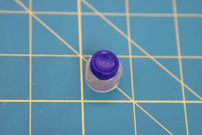 How To Secure Button Backing Into Button Cover - Maxant-Button-Cover-Kit - Baratti Blouson Dress - MDF457 - Mood Fabrics Sewciety Blog Secure the button backing with the blue tool included in the kit.