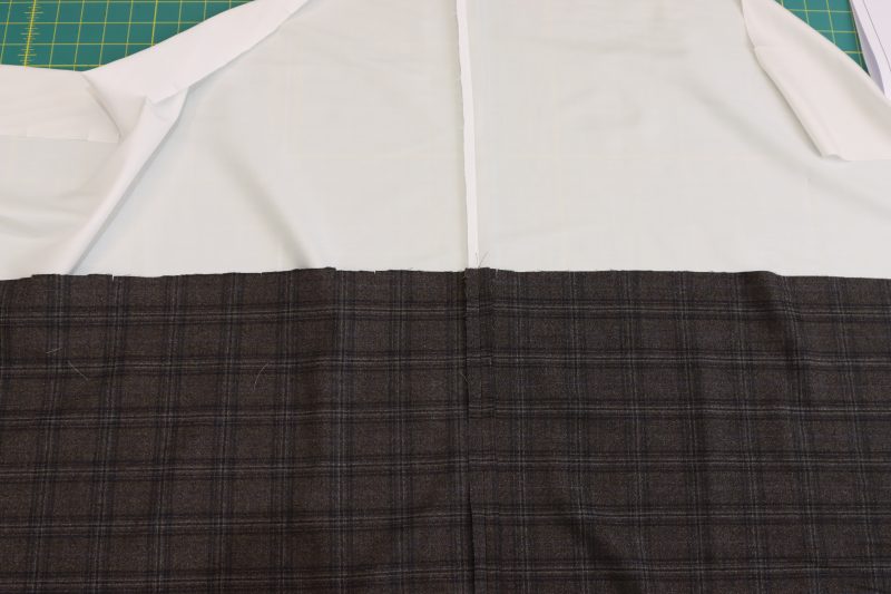 How To Iron Side Seams Open And Flat - Super 130s Wool Twill Suiting Made in Italy Charcoal Gray Navy Plaid Deadstock - Mood Fabrics - Oxford Pleated Skirt and Tie Free Sewing Pattern Tutorial - MDF460 - Mood Fabrics Sewciety Blog - Iron the side seams open and flat for both the inner skirt and shell pieces.