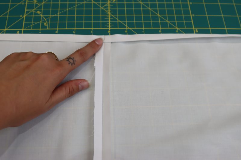 How To Fold Inner Skirt Hem - Egyptian Cotton Shirting Optic White Giza Collection - Mood Fabrics - Oxford Pleated Skirt and Tie Free Sewing Pattern Tutorial - MDF460 - Mood Fabrics Sewciety Blog - Fold inner skirt piece up by ½ inch then another ½ inch to create double folded hem.