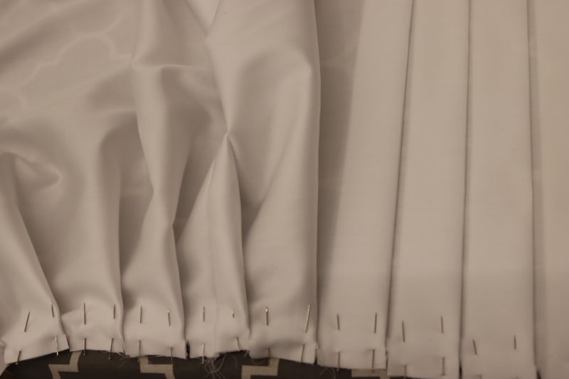 How To Iron Inner Skirt Pleats - Egyptian Cotton Shirting Optic White Giza Collection - Mood Fabrics - Oxford Pleated Skirt and Tie Free Sewing Pattern Tutorial - MDF460 - Mood Fabrics Sewciety Blog - Begin ironing down the pleats on the inner skirt layer.