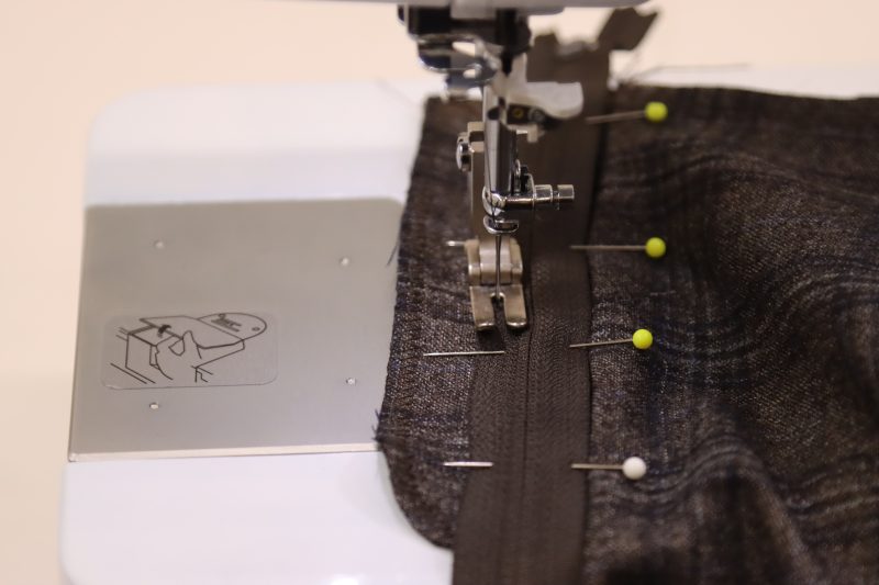 How To Sew Zipper Tape To Fly Facing - Regular Zipper 9 Inch YKK 916 After Dark - Mood Fabrics - Oxford Pleated Skirt and Tie Free Sewing Pattern Tutorial - MDF460 - Mood Fabrics Sewciety Blog - Sew down the center of the rightmost side of the zipper tape.