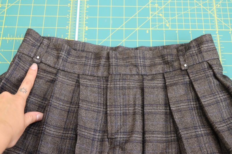 How To Pin Belt Loops To Waistband - Super 130s Wool Twill Suiting Made in Italy Charcoal Gray Navy Plaid Deadstock - Mood Fabrics - Oxford Pleated Skirt and Tie Free Sewing Pattern Tutorial - MDF460 - Mood Fabrics Sewciety Blog - Evenly pin the belt loops to the waistband of the skirt.