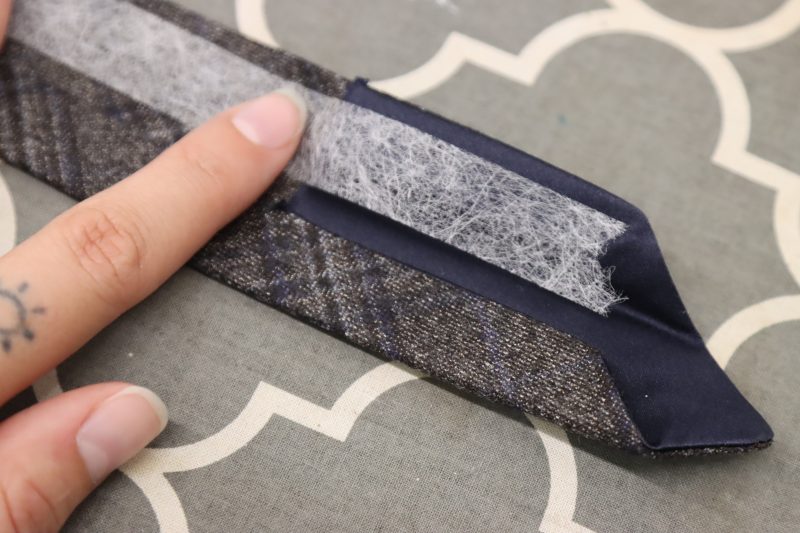 How To Iron Hem Tape Inside Tie Fold - Dritz Ultra Light Stitch Witchery - Mood Fabrics - Oxford Pleated Skirt and Tie Free Sewing Pattern Tutorial - MDF460 - Mood Fabrics Sewciety Blog - Iron hem tape into the folded edge of the tie to keep the raw edges tucked inside.