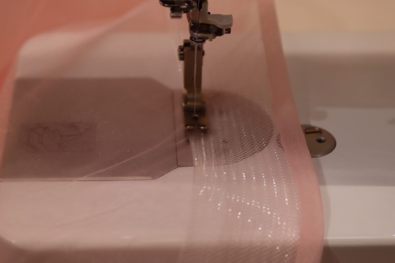 How To Fold Horsehair To Wrong Side - Horsehair - Mood Fabrics - Glinda Gown Free Sewing Pattern Tutorial - MDF463 - Mood Fabrics Sewciety Blog - Fold the horsehair braid over the raw edge and sew it down on the opposite side.