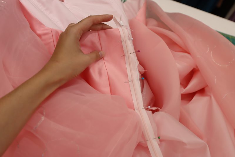 How To Sew Zipper To Back Opening - Satin - Mood Fabrics - Glinda Gown Free Sewing Pattern Tutorial - MDF463 - Mood Fabrics Sewciety Blog - Sew the zipper right sides together with one of the sides of the back opening of the dress.