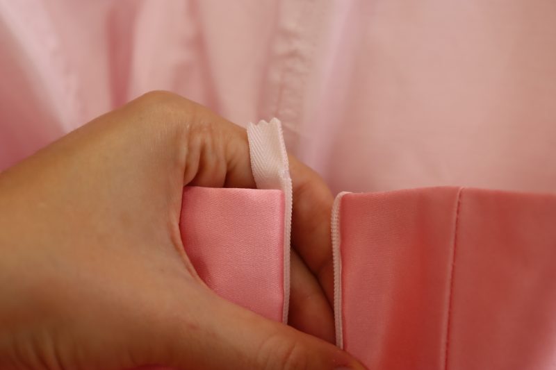 How To Sew Zipper Tape Into Seam Allowance - Satin - Mood Fabrics - Glinda Gown Free Sewing Pattern Tutorial - MDF463 - Mood Fabrics Sewciety Blog - Tuck the extra zipper tape into the seam allowance at the top of the dress.
