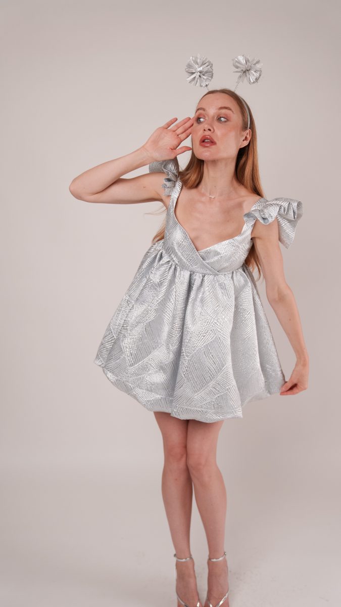 Close-up of Dreamline Babydoll Dress Alien costume with voluminous silver fabric, bow straps, and playful alien antenna headband.