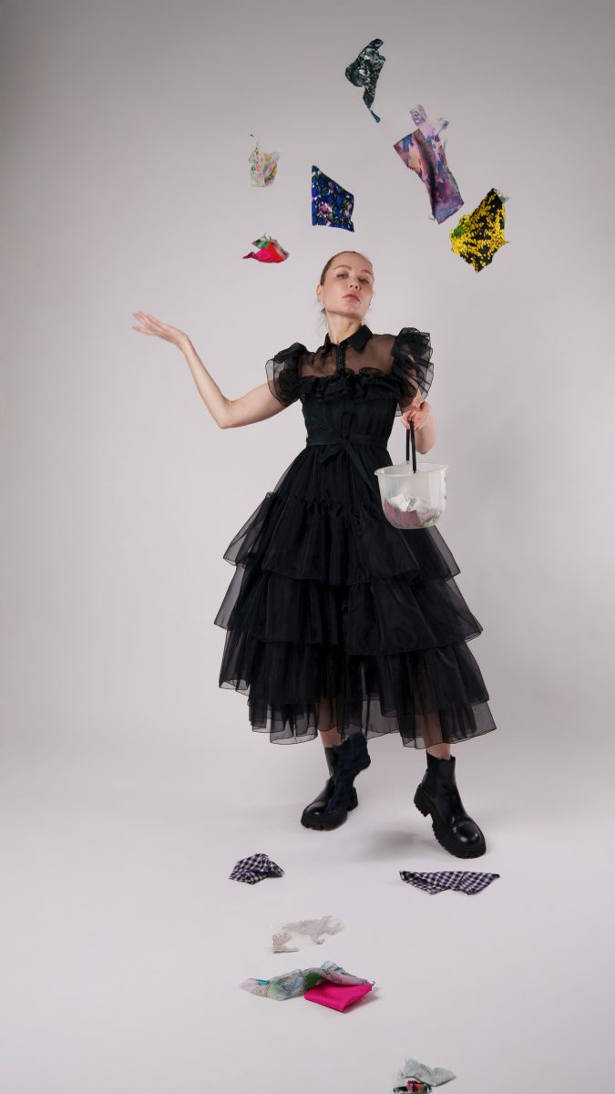 Nightshade black tulle Halloween costume with voluminous tiered skirt, model tossing colorful fabric scraps in the air.