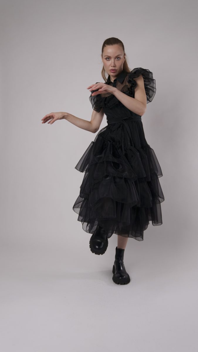 Woman in a layered black tulle ruffle gown with puff sleeves and boots, styled as a Wednesday Addams Halloween costume idea with the Roslyn Skirt & Parker Corset pattern.