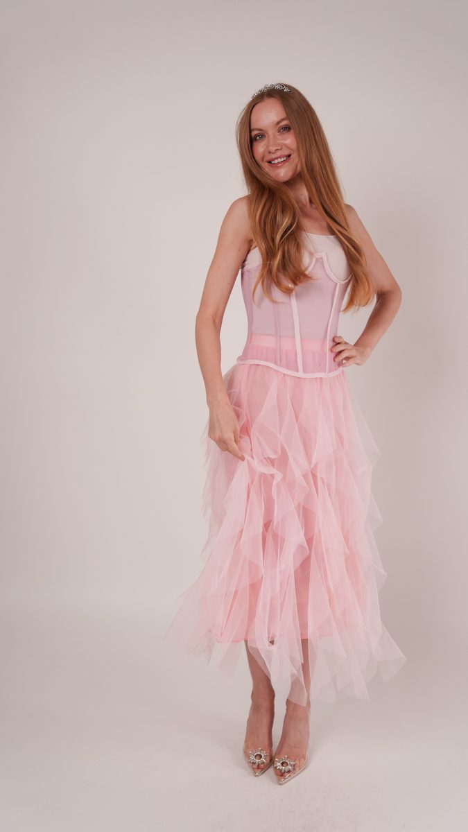 Playful pose showcasing Roslyn Ruffled Midi Skirt’s layered ruffles with the Parker Corset, styled as a whimsical Glinda costume for Halloween.
