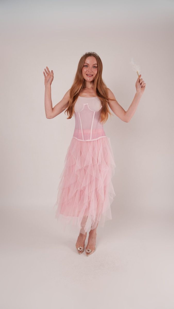 Woman in a pink tulle layered gown with corset bodice and tiara, holding a wand, styled as a Fairy Princess Halloween costume idea using the Parker Corset & Roslyn Skirt patterns.