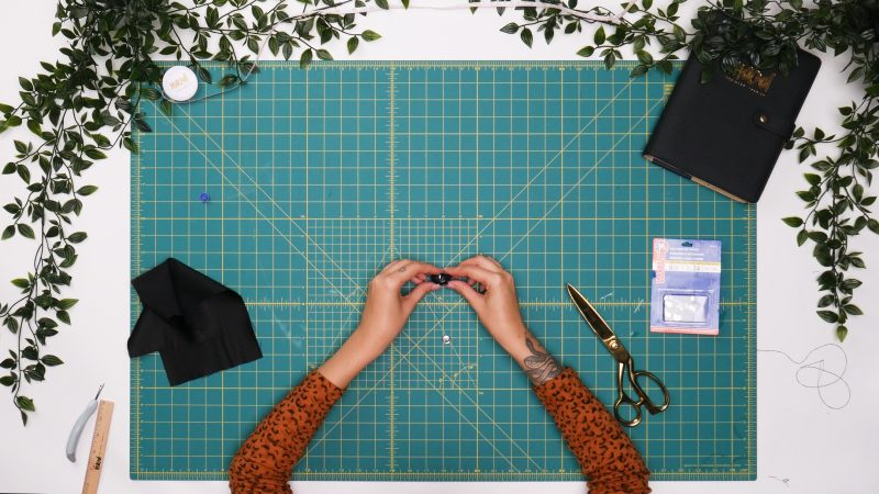 How To Tuck Fabric Into Button Shell - - Mood Fabrics - Nolita Vest and Skirt Set Free Sewing Pattern Tutorial - MDF466 MDF467 - Mood Fabrics Sewciety Blog - Tuck the raw edges of the fabric into the back of the button shell.