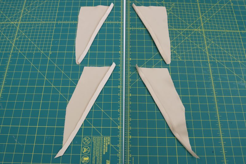 How To Iron Diagonal Edge Of Pocket Facings - Satin - Mood Fabrics - Firenze Blouse Trousers Free Sewing Pattern Tutorial - MDF464 - Mood Fabrics Sewciety Blog - Iron a ½ inch hem on the diagonal edge of the pocket facings.