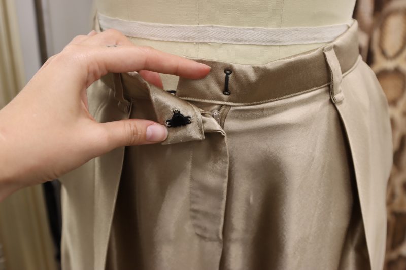 How To Sew Hook And Eye By Hand - Satin - Mood Fabrics - Firenze Blouse Trousers Free Sewing Pattern Tutorial - MDF464 - Mood Fabrics Sewciety Blog - Hand sew the hook and eye closure to the waistband of the pants.