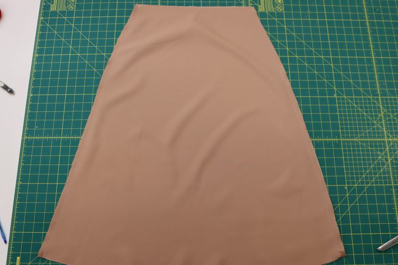 How To Pin Sew Lining Side Seams - Satin - Mood Fabrics - Nolita Vest and Skirt Set Free Sewing Pattern Tutorial - MDF466 MDF467 - Mood Fabrics Sewciety Blog - Pin and sew the side seams of the skirt lining, leaving a gap for the zipper at the top of one of the seams.