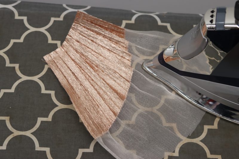 How To Iron Opposite Edge Flat - Pleated Luxury Burnout Brocade - Mood Fabrics - Nolita Vest and Skirt Set Free Sewing Pattern Tutorial - MDF466 MDF467 - Mood Fabrics Sewciety Blog - Iron the bottom edge of each ruffle to create the flared look.