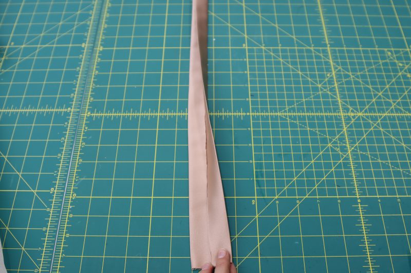 How To Fold Waistband - Satin - Mood Fabrics - Nolita Vest and Skirt Set Free Sewing Pattern Tutorial - MDF466 MDF467 - Mood Fabrics Sewciety Blog - Fold and iron the long sides of the waistband in towards the middle, then fold and iron it in half again.