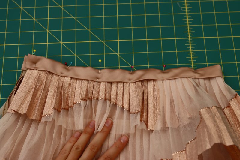 How To Pin Sew Waistband To Waistline - Satin - Mood Fabrics - Nolita Vest and Skirt Set Free Sewing Pattern Tutorial - MDF466 MDF467 - Mood Fabrics Sewciety Blog - Pin and sew the waistband to the waistline of the skirt.