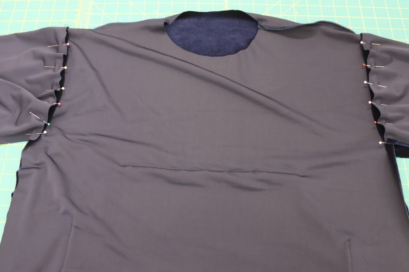 How To Pin Sew Arm Openings - Stretch Velour - Mood Fabrics - Tarrytown Tracksuit Free Sewing Pattern Tutorial - MDF471 - Mood Fabrics Sewciety Blog - Pin and sew the sleeves to the marked arm opening on the top.
