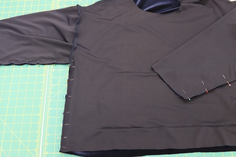 How To Pin Sew Sleeves Side Seams - Stretch Velour - Mood Fabrics - Tarrytown Tracksuit Free Sewing Pattern Tutorial - MDF471 - Mood Fabrics Sewciety Blog - Pin and sew the sleeves and side seams shut.