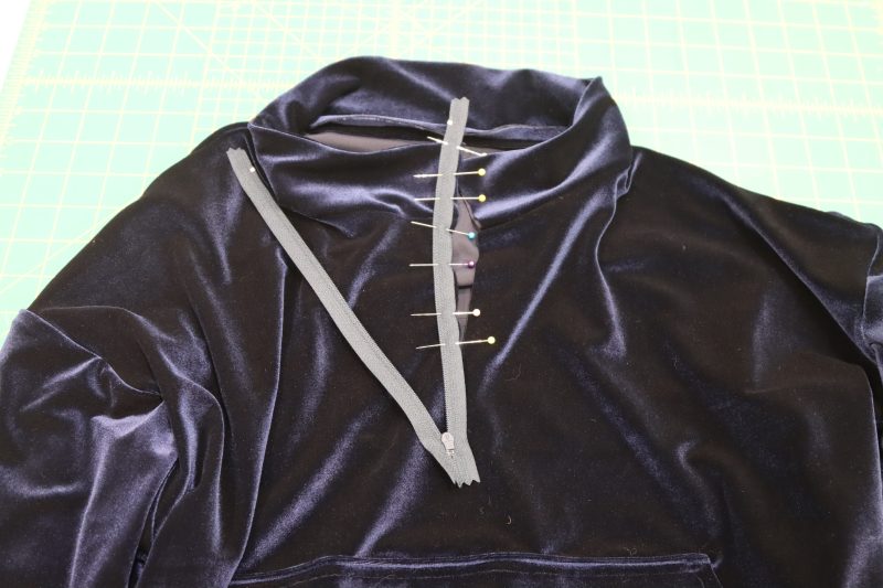 How To Pin Sew Right Side Zipper To Collar - 9 Inch Zipper - Mood Fabrics - Tarrytown Tracksuit Free Sewing Pattern Tutorial - MDF471 - Mood Fabrics Sewciety Blog - Pin and sew the right hand side of the zipper right sides together with the outer layer of the collar.