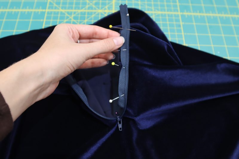 How To Pin Sew Left Side Zipper To Collar - 9 Inch Zipper - Mood Fabrics - Tarrytown Tracksuit Free Sewing Pattern Tutorial - MDF471 - Mood Fabrics Sewciety Blog - Pin and sew the left hand side of the zipper right sides together with the outer layer of the collar.