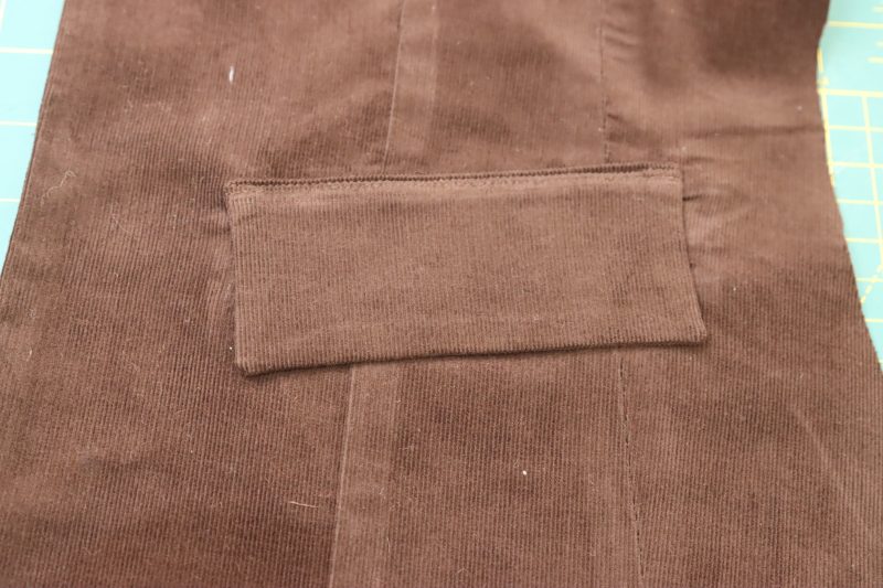 How To Pin Sew Pocket Flaps Above Welts - Featherwale Cotton Corduroy - Mood Fabrics - Fawn Mini Dress Free Sewing Pattern Tutorial - MDF476 - Mood Fabrics Sewciety Blog - Sew the pocket flaps above the welt pockets.