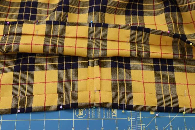 How To Fold Hem - Virgin Wool Twill - Mood Fabrics - Silverstone Mini Dress Free Sewing Pattern Tutorial - MDF489 - Mood Fabrics Sewciety Blog - Fold the hem up by 1 inch twice, then press and pin in place.
