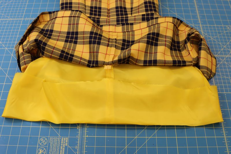 How To Iron Lining Hem - Bemberg Lining - Mood Fabrics - Silverstone Mini Dress Free Sewing Pattern Tutorial - MDF489 - Mood Fabrics Sewciety Blog - Iron, pin, and sew along the bottom hem of the lining.