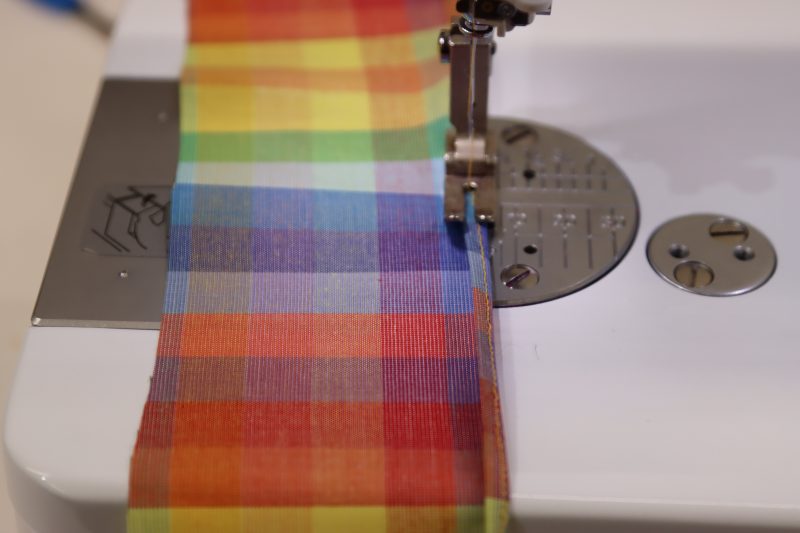 How To Fold First Hem - Rainbow Checks Cotton Shirting - Mood Fabrics - Bayport Blouse Free Sewing Pattern Tutorial - MDF494 - Mood Fabrics Sewciety Blog - Fold the first hem and sew another ⅛ inch hem to encase the raw edges.