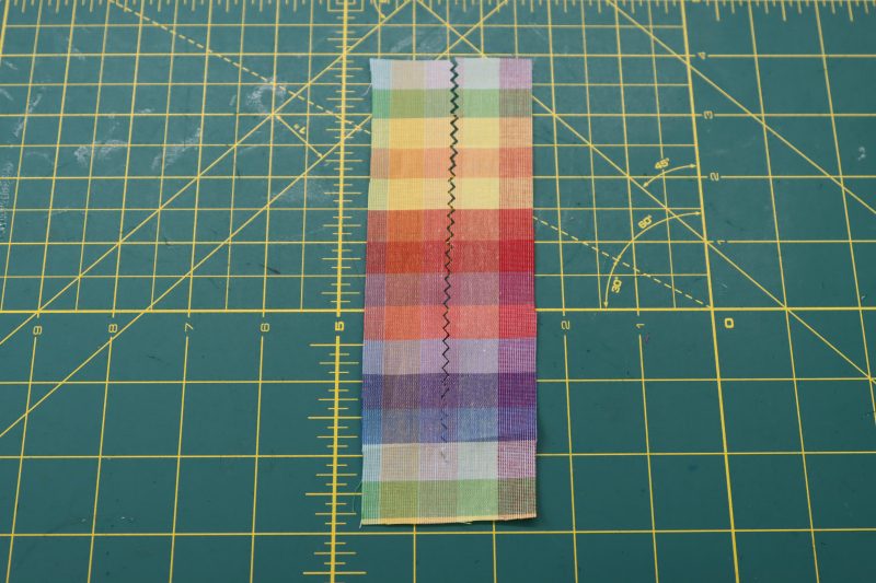 How To Cut Slit In Keyhole Facing - Rainbow Checks Cotton Shirting - Mood Fabrics - Bayport Blouse Free Sewing Pattern Tutorial - MDF494 - Mood Fabrics Sewciety Blog - Cut a slit in the keyhole facing with pinking shears.